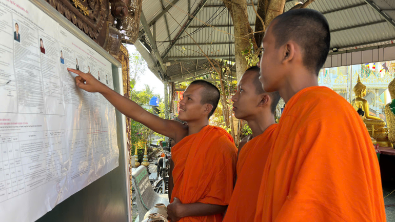 Tăng sinh Khmer tìm hiểu danh sách ứng cử viên niêm yết tại chùa.