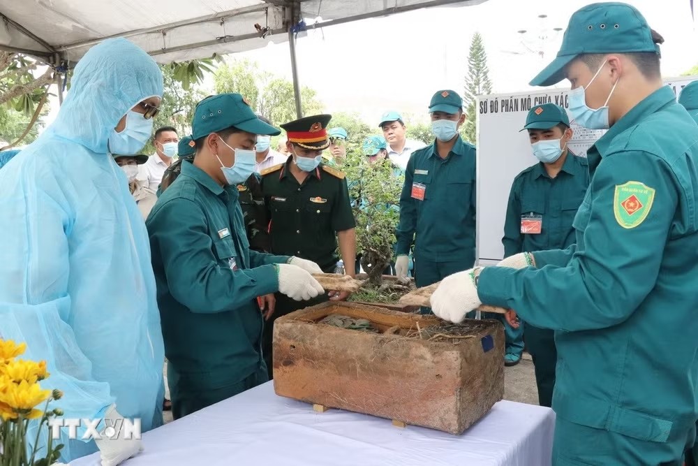 Lấy mẫu xác định danh tính hài cốt liệt sỹ. (Ảnh: TTXVN)